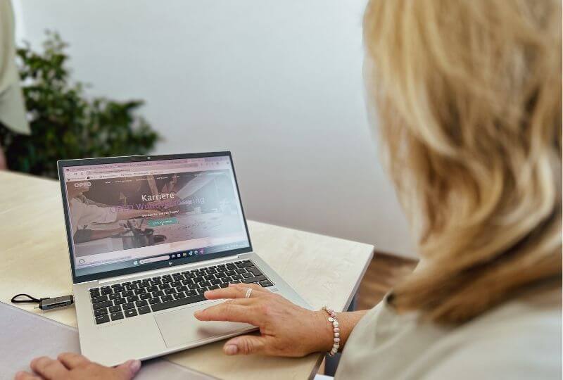Bewerberin sitzt vor Laptop und möchte über die OPED Wundversorgungs-Website ihre Bewerbung einreichen