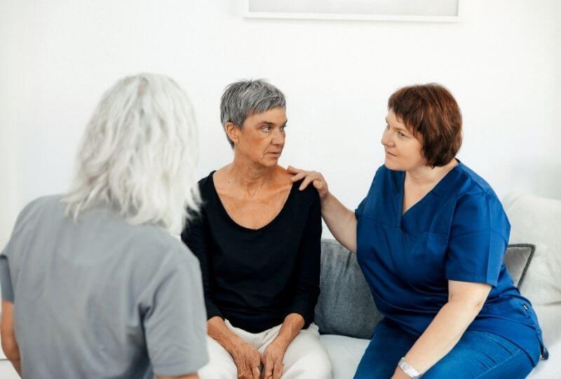 Wundversorgerin von OPED Wundversorgung im Gespräch mit einer Patientin und einer Pflegekraft: In häuslicher Umgebung erklärt sie dem Pflegedienst die Wundversorgung und unterstützt die gemeinsame Betreuung der Patientin – interdisziplinäre Zusammenarbeit für optimale Versorgungsqualität.