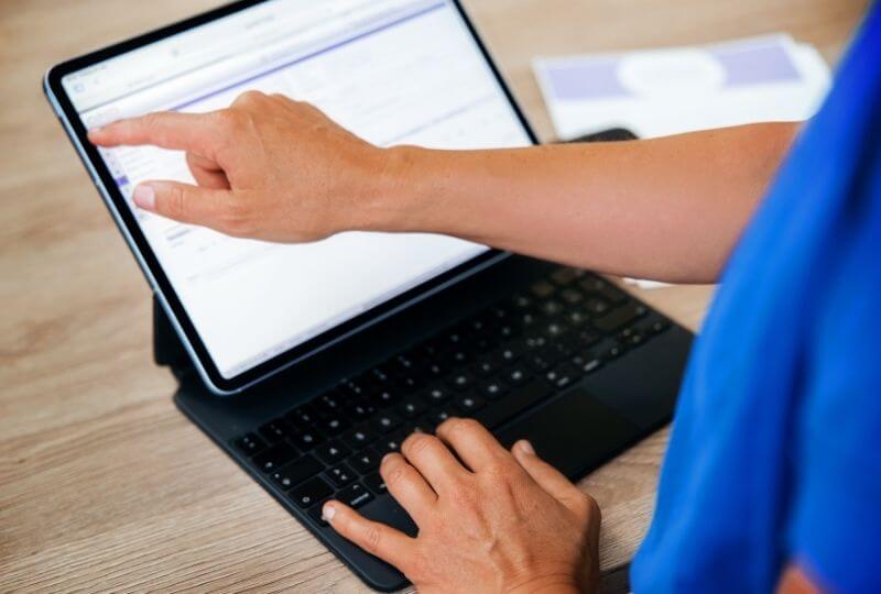 Wundversorgerin gibt Patientendaten in ein Tablet ein.