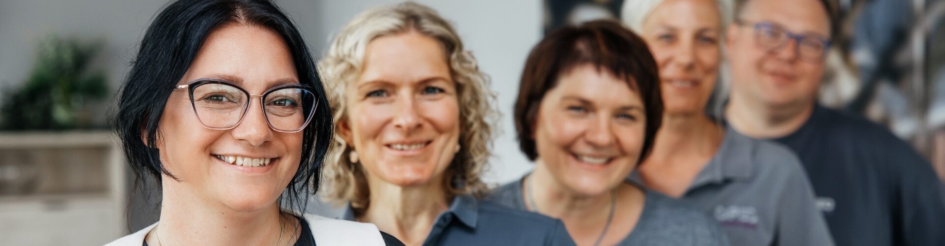 Auf dem Bild sieht man eine Gruppe von unterschiedlichen Personen, die schräg hintereinander stehen.