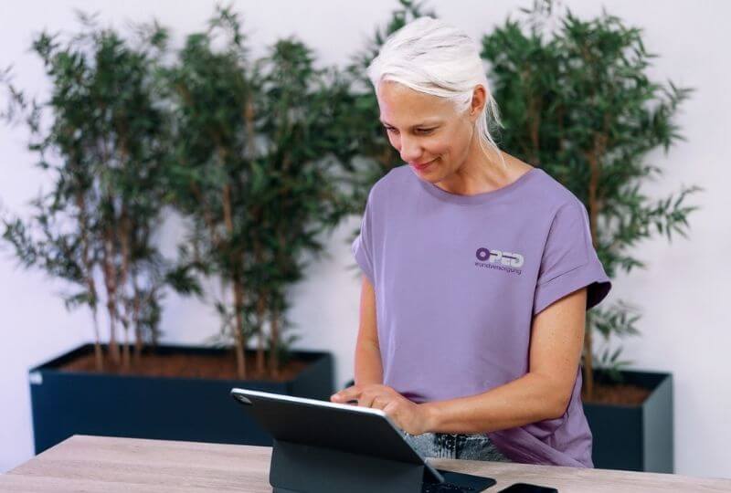 Wundversorgerin arbeitet am Hochtisch an ihrem Tablet