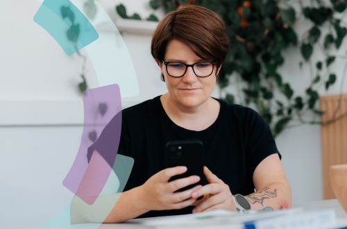 Mitarbeiterin von OPED Wundversorgung liest auf ihrem Smartphone die neusten Informationen zur Erstattungsfähigkeit von Wundauflagen.