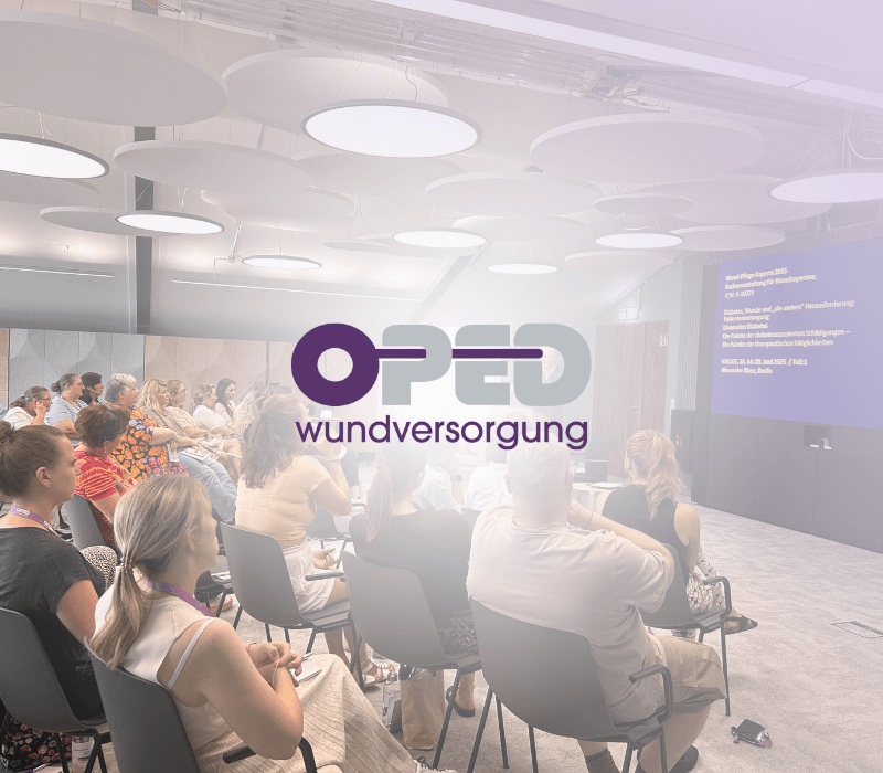Im Hintergrund sieht man einen Veranstaltungsraum mit sitzenden Personen. Im Vordergrund sieht man das Logo von OPED Wundversorgung.