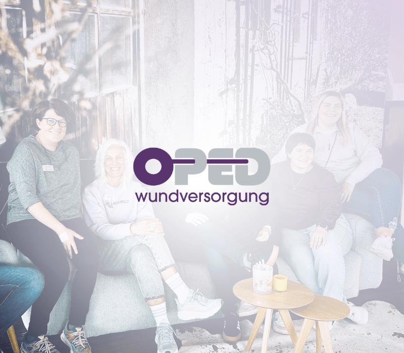 Im Hintergrund sieht man eine Gruppe unterschiedlicher Personen auf einem Sofa in einer schicken Lounge. Im Vordergrund sieht man das Logo von OPED Wundversorgung